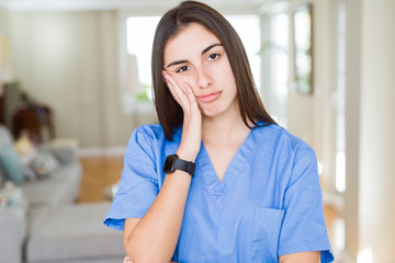 Fototapeta premium Beautiful young nurse woman at the clinic thinking looking tired and bored with depression problems with crossed arms.