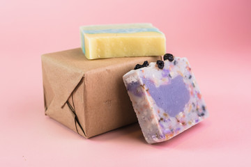 colorful handmade soaps and gift box on pink background