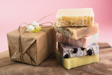 colorful handmade soaps and gift box on pink background