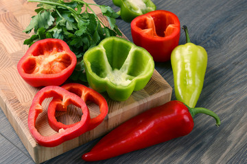cut red and green bell peppers on wooden background