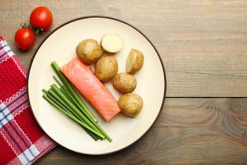 Boiled young potatoes with red fish, onions and cherry tomatoes