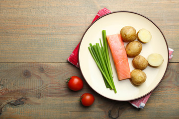 Boiled young potatoes with red fish, onions and cherry tomatoes