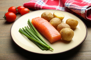 Boiled young potatoes with red fish, onions and cherry tomatoes