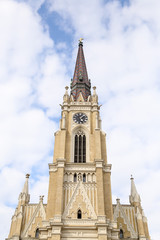 Obraz premium The Name of Mary Church, Novi Sad catholic cathedral during a spring partly cloudy day.