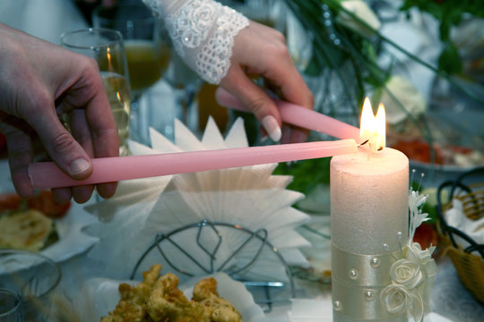 bride and groom light the wedding candle at the ceremony. unity of two souls.