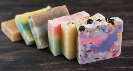 colorful handmade soaps on dark wooden background