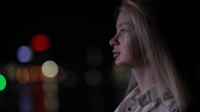 Face profile of beautiful woman in night city, slow motion