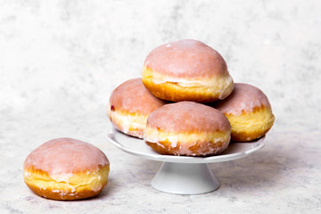 Traditional Polish donuts with frostng on light background. Tasty doughnuts with jam.