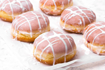 Traditional Polish donuts with white frosting on white background. Tasty doughnuts with jam.