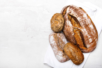 Tasty dark bread and buns  on white background, copy space. Bakery products, wholemeal bread and...
