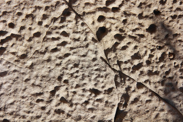 texture rough brown gray surface of an old cement wall with cracks, patterns and divorces