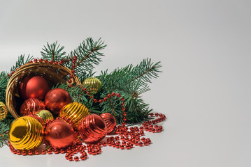 Composition of an inverted wicker basket with toys of red and gold color to decorate the Christmas...