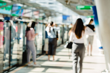 Blurred of people waiting on electric skytrain station with automatic gateway