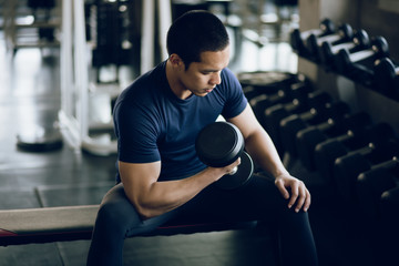 Fototapeta na wymiar Young muscular lifting weights at gym