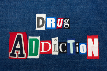 Fototapeta na wymiar DRUG ADDICTION text word collage, colorful fabric on blue denim, abuse and treatment concept, horizontal aspect