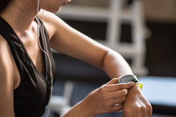 Beautiful young woman using smart watch at the gym