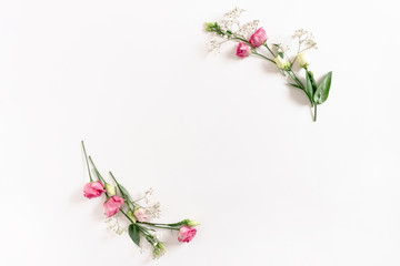 Border frame made of eustoma and gypsophila flowers on white background