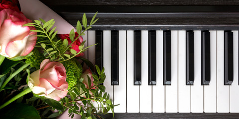 bouquet of flowers on the keys of the piano. Music romantic composition flat lay top view Musical...