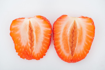 close up view of fresh ripe red strawberry halves on white background