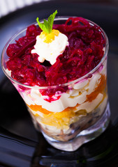  salad herring under fur coat from vegetables in verrin on black plate