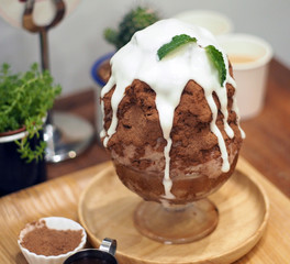 Glass bowl delicious shaved iced milk coated with chocolate powder then topped with white malt...
