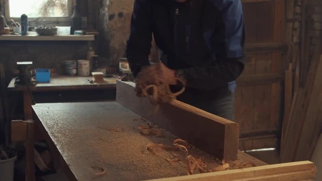 craftsman planing wooden beam with slicer