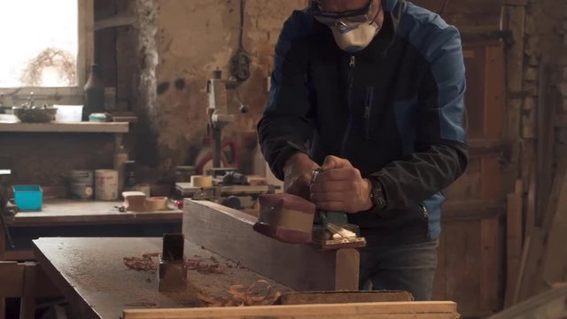 Craftsman sanding wooden beam