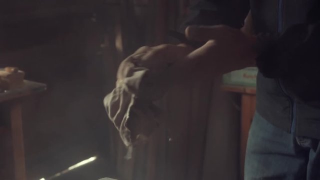 man cleaning his dusty hands with an old rag