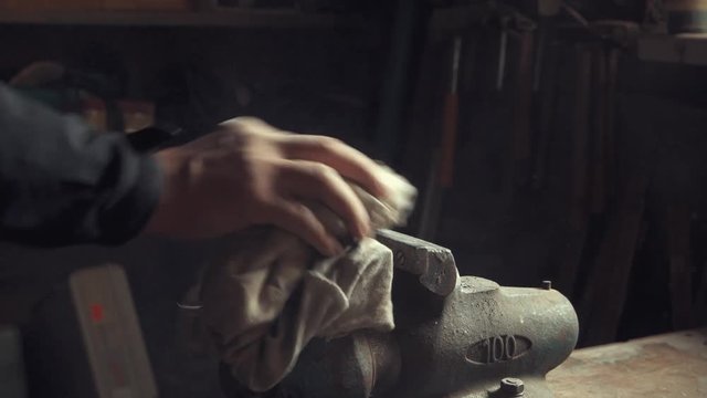 Hands cleaning an old dusty vice