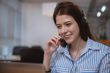Close up of a beautiful friendly female customer support operator working at the call center, using...