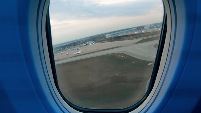 Window of an aircraft with the take-off shown from it
