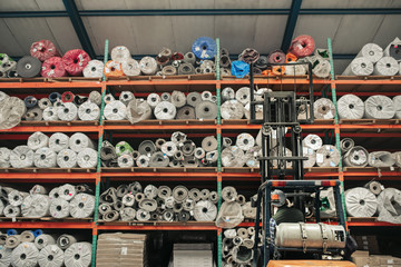 Forklift driver removing stock off shelves in a large warehouse