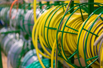 stacks of rolls yellow pvc plastic pipe on the counter in the store. Sale Hoses in the garden of various manufacturers, on shelves in store. Hose for watering in the store