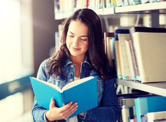 education, high school, university, learning and people concept - smiling student girl reading book at library