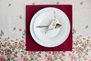 white plates on the background of the tablecloth, floral print. creative background