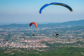 Loznica, Serbia April 21, 2019: Paraglider flying over mountains Gucevo and the Drina River. On the photo there is a panorama of Loznica. © nedomacki