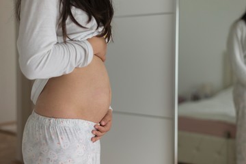 girl holding her pregnant stomach. five month of pregnancy