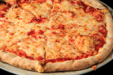 top view of whole sliced cheese pizza on round white plate