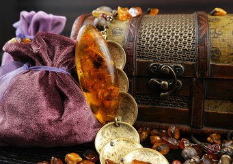 Natural amder, bijouterie and velvet pouches for jewelry on the dark wooden board