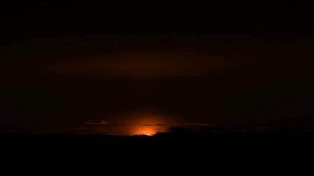 Superzoom plan timelapse sunset through sunset clouds in orange tones. Low key