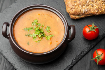 Vegetable soup, two cherry tomatoes, and two slices of bread