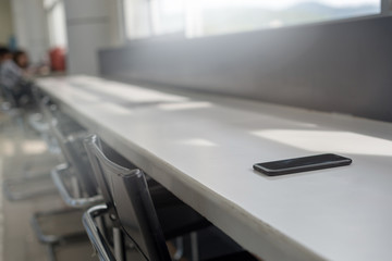 smart phone place on table in public library in selective focus, Concept : Forget / lost.