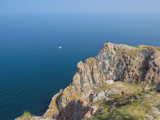 Tourist on the top of the cliff of Olkhon Island. View of Lake Baikal .