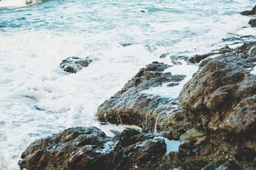 Waves crash into rocky crevices along the California coast