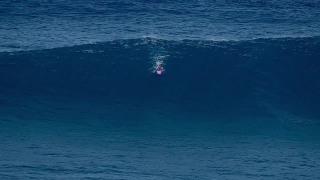 Surfer tries to ride the wave at the famous Jaws (Peahi) surf spot in Maui, Hawaii