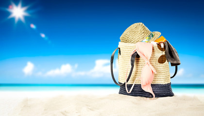 Summer beach background with summer bag on sand 