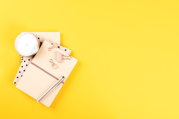 Notebook ,pen and alarm clock on a bright yellow background.Accessories office concept.Business Idea. Time to school.Top View.Flat Lay. Copy space for Text.