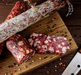 Traditional sausage and sausage with mold. Sliced sausage salami and  knife on wooden board with...