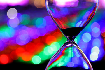 Closeup to hourglass with colorful bokeh background