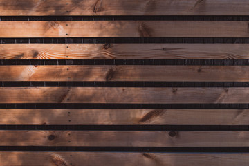 Natural dark wooden planks with sun ray. Linear background with copy space.